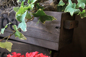 Blumenkasten aus Holz in Braun mit Schriftzug
